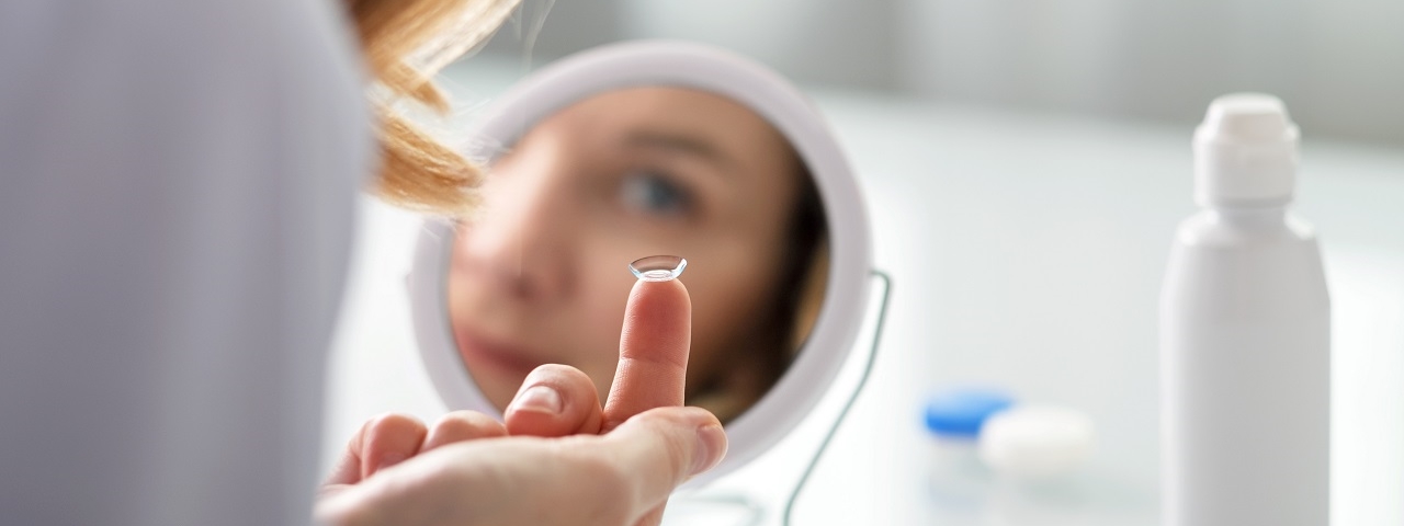 woman putting on contact lens